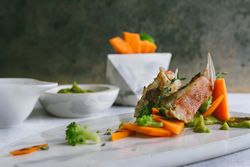 grilled scorpion fish with mashed peas and carrot sticks, on a marble plate
