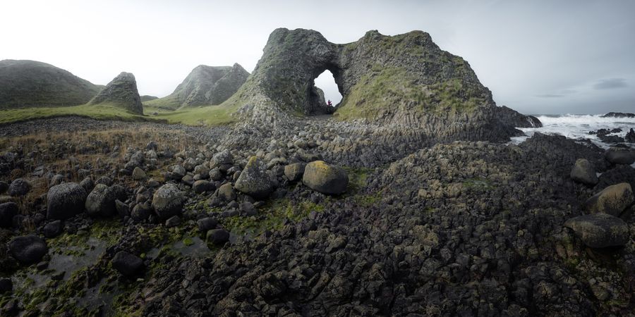 Woman standing inside rocky cave
