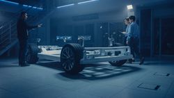 Automobile Design Engineers Talking while Working on Electric Car Chassis Prototype