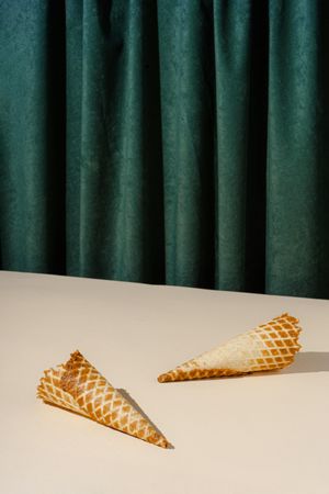 Waffle cones lying in front of green curtain background