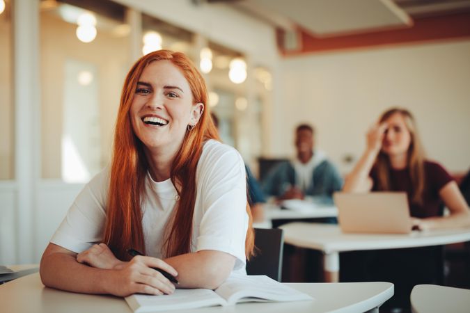 Portrait of smiling woman sitting in university classroom