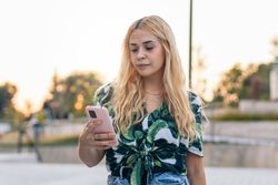 Blonde woman using mobile phone outdoors
