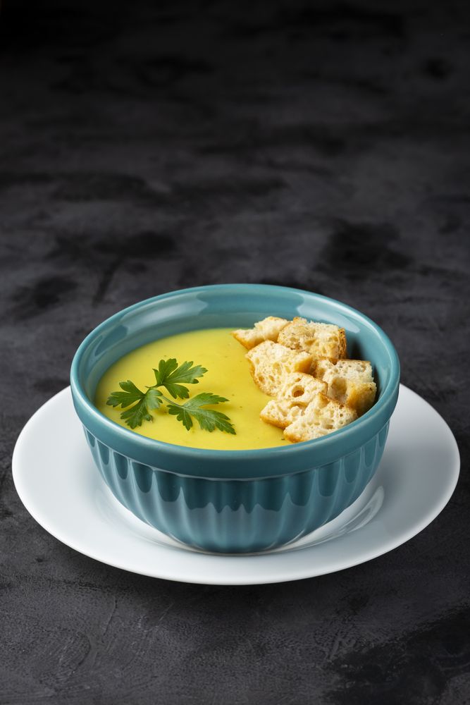 Bowl with onion soup and croutons on the table.