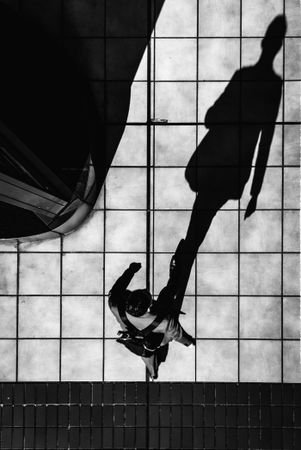 High angle view of a man walking in grayscale