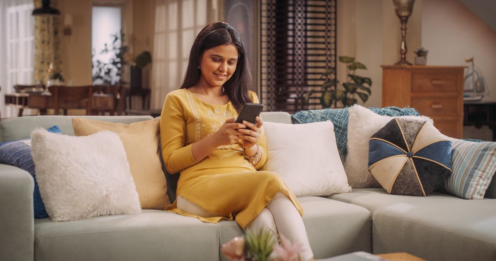 Stylish Woman Enthralled in Smartphone Use at Home