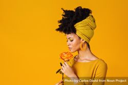 Portrait of Black woman holding a rose to her nose 4AnDmb