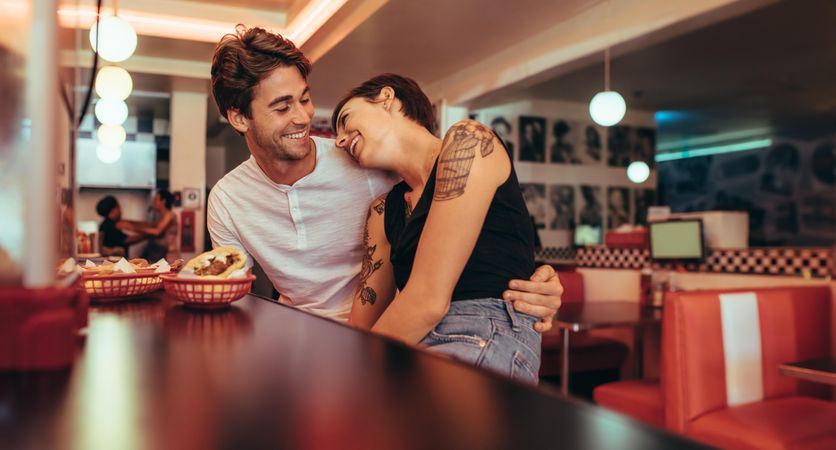 Romantic couple sitting in a restaurant with food on the table