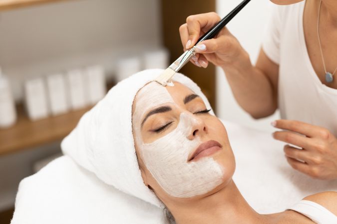 Female having a relaxing face mask professionally applied by beautician