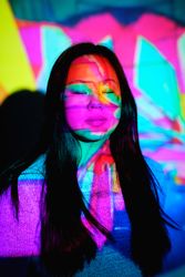 Asian woman under colorful lights in studio