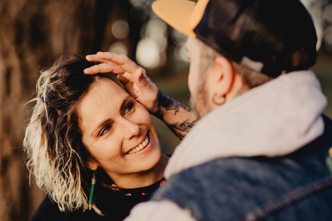 Happy couple hugging near tree in park
