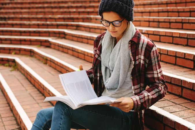 Focused student  with textbooks at college campus