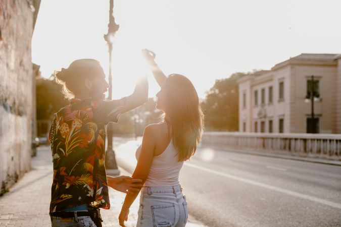 Happy playful couple on street in sunset