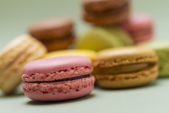 Close up of macaroons scattered on a green table