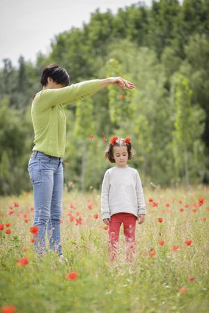 Woman putting flower petals on daughter’s head