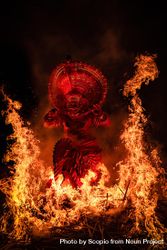 Man performing Theyyam ritual form of dance worship surrounded by fire 41vgLb