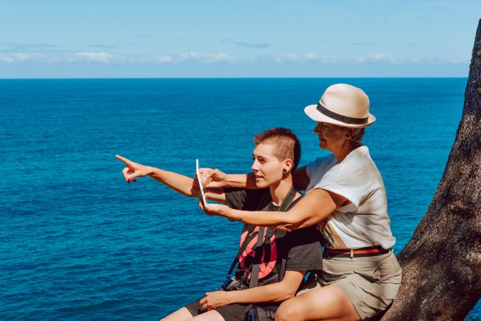 Stylish woman with tablet in hands sightseeing on the coast