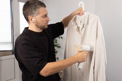 Man Steaming Shirt With Handheld Steamer