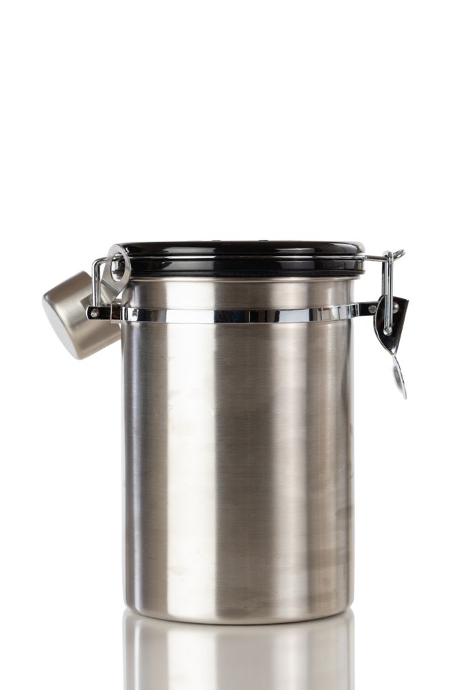 Stainless steel coffee ground container and scooper isolated on plain background