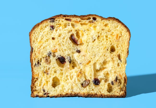Panettone sliced in half, minimalist on a blue background