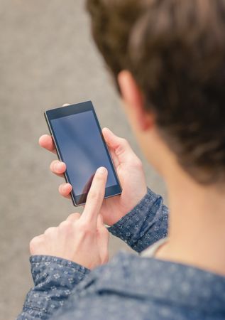 Hipster male using a smart phone outdoors