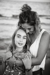 Beautiful mother and daughter embracing on beach