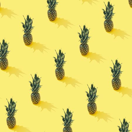Tropical pineapple pattern on pastel yellow background