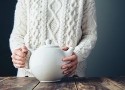 Woman with tea pot on wooden table