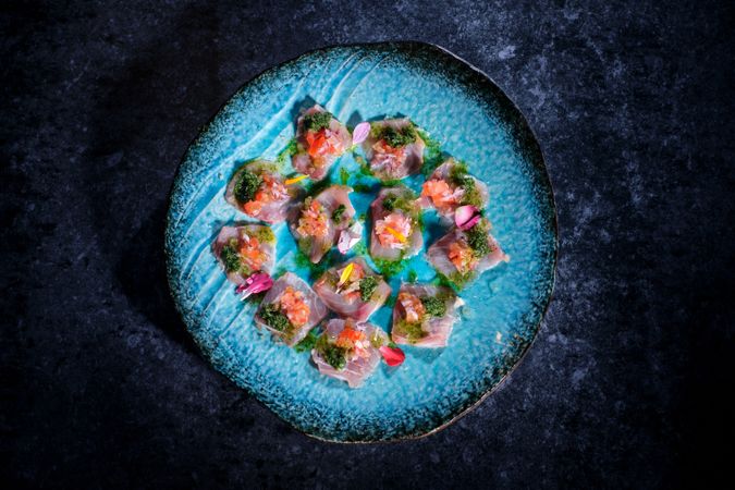 Plate with delicious fish dish on marble surface