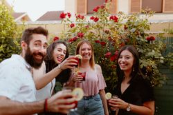 Group of cheerful friends clinking glasses at party
