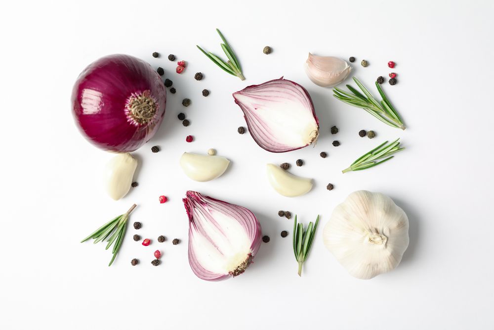 Flat lay composition with red onion and spices on plain background