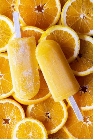 Two ice cream popsicles and orange slices