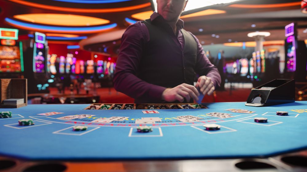 Casino Card Game Table: Professional Dealer Running a Blackjack Game. Anonymous Male Croupier Dealing Playing Cards