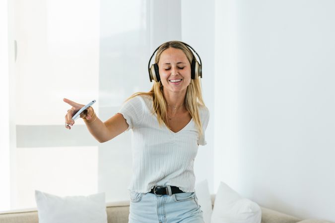 Cheerful woman listening to music in headphones