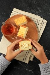 Person holding grilled cheese sandwich with tea