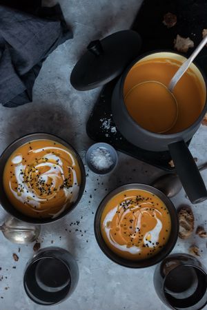 Bowls with pumpkin cream soup on table