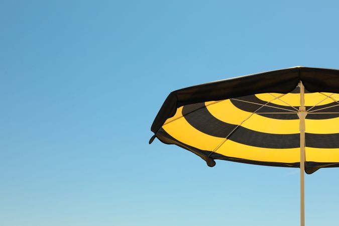 Striped beach umbrella against blue sky