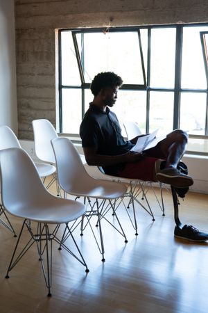 Man with prosthetic leg sitting going over his notes