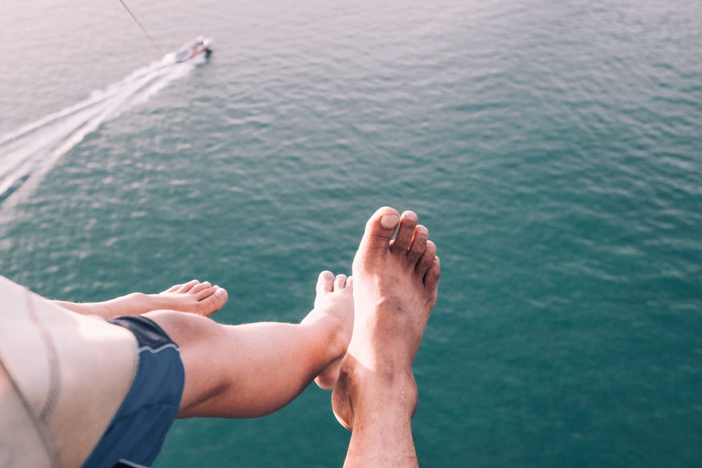 Feet dangling with motorboat below