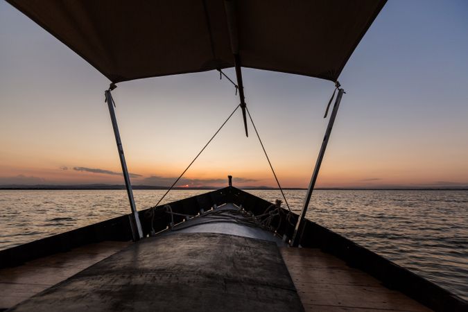 Front of boat riding along sea