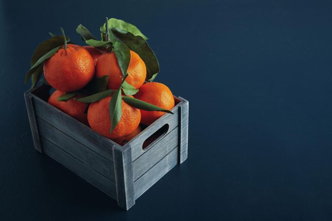 Box of tangerines on blue background