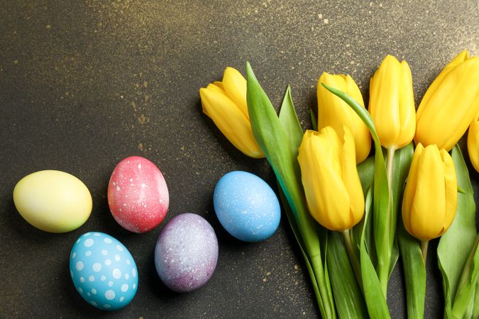 Decorated eggs with flowers on golden background. Space for text