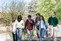 Multi-ethnic group of students walking through campus to class 0JGonN