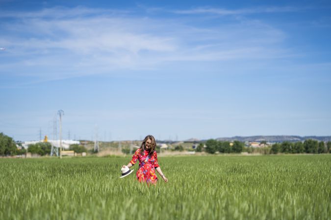 Young woman throwing up hat in field