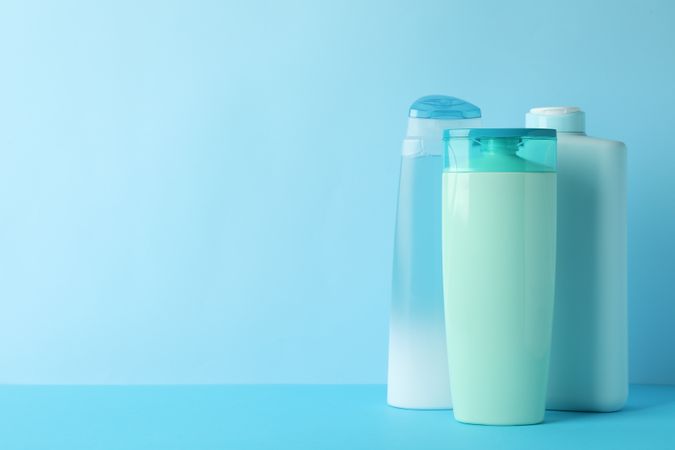 Blank bottles for cosmetics on blue background