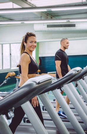 Man and woman working out on treadmills in gym