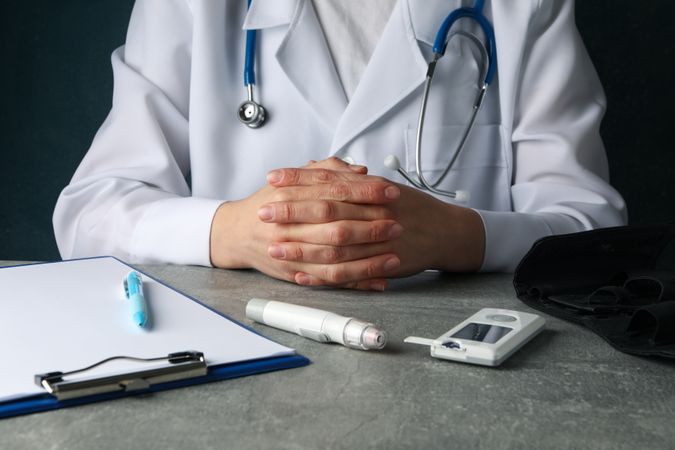 Doctor sits with folded arms. Diabetes test