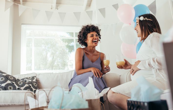 Happy pregnant woman and her friend at baby shower