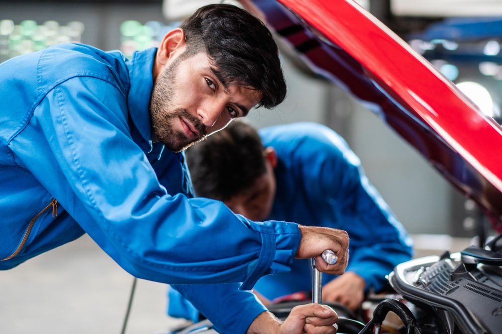 Handsome automobile mechanic man checking car damage