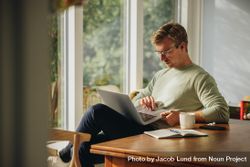 Man starting morning at home checking emails on laptop 4mxKo5