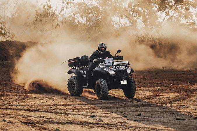 Person riding ATV on brown sand